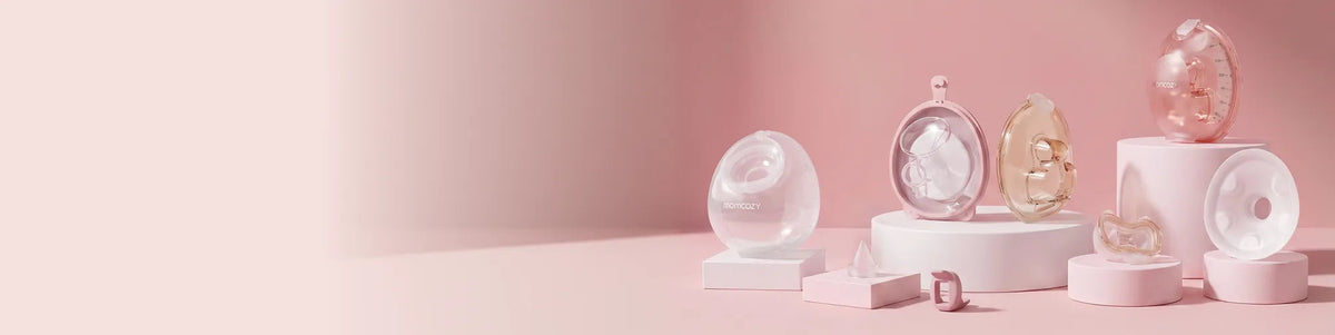 Momcozy wearable breast pumps on a soft pink background